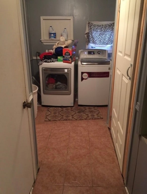 laundry area with light tile flooring and washing machine and dryer