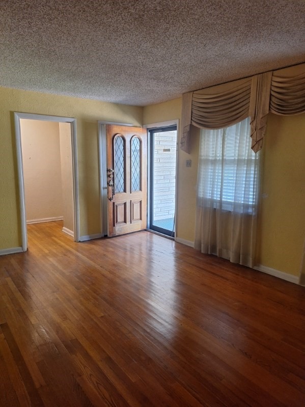 foyer with wood-type flooring and a textured ceiling