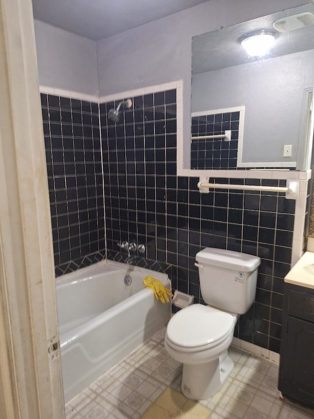 full bathroom featuring vanity, toilet, tile walls, and bathtub / shower combination