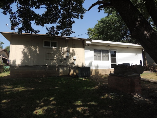 rear view of property featuring a yard and central AC