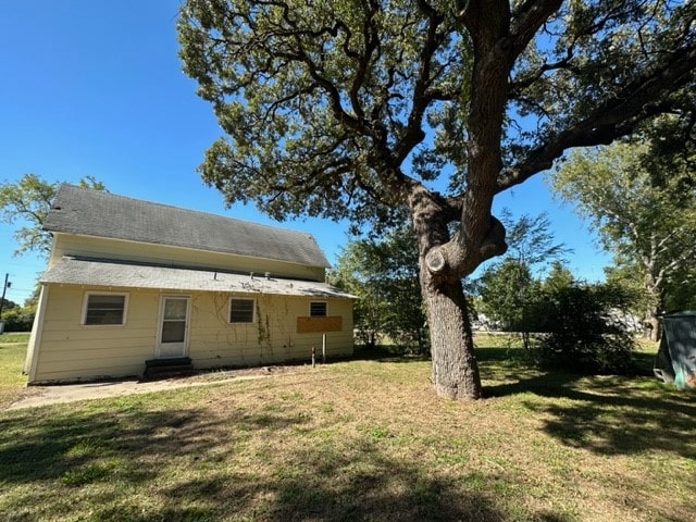 back of property with a lawn