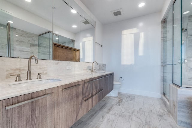 bathroom featuring toilet, double sink vanity, tasteful backsplash, tile flooring, and an enclosed shower