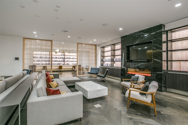 living room featuring a premium fireplace, dark parquet floors, floor to ceiling windows, and plenty of natural light