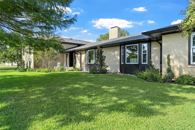 rear view of property with a lawn