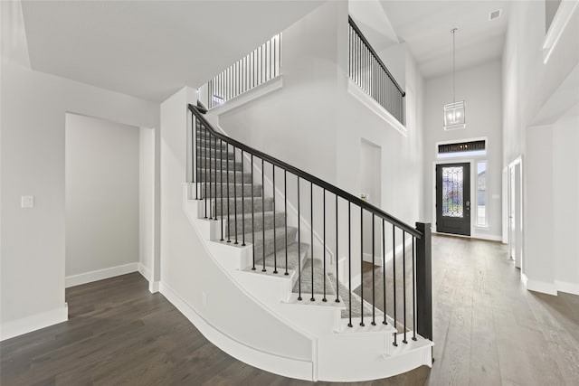 entryway featuring dark hardwood / wood-style flooring and a towering ceiling