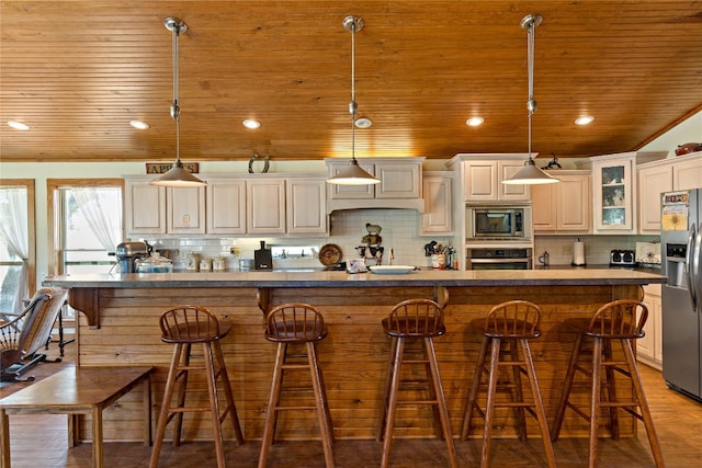 kitchen with tasteful backsplash, stainless steel appliances, and pendant lighting