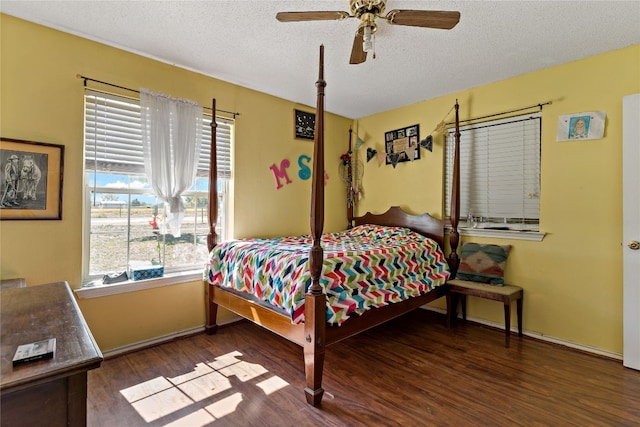 bedroom featuring dark hardwood / wood-style floors, ceiling fan, and a textured ceiling