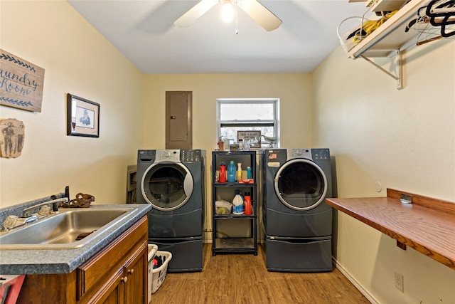 clothes washing area with light wood-type flooring, ceiling fan, sink, and washer and dryer