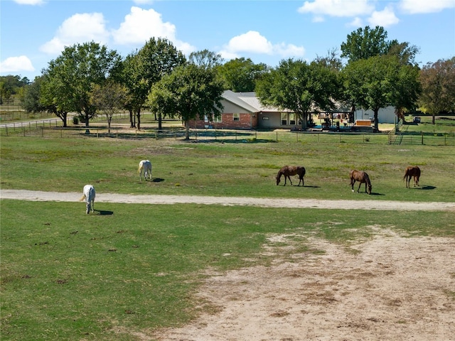 view of property's community featuring a rural view and a lawn