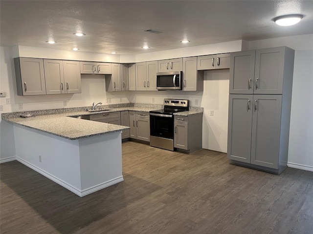 kitchen with stainless steel appliances, dark hardwood / wood-style flooring, sink, and gray cabinetry