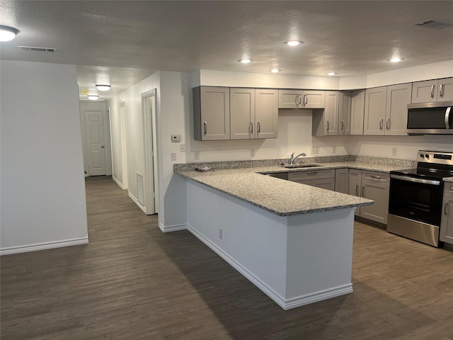 kitchen with sink, gray cabinets, stainless steel appliances, and kitchen peninsula