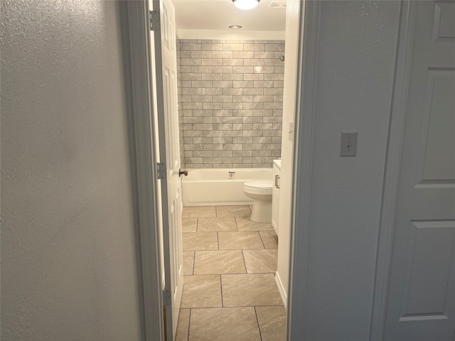 full bathroom with tiled shower / bath combo, vanity, and toilet