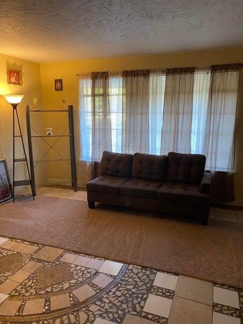 living room with a textured ceiling and tile floors