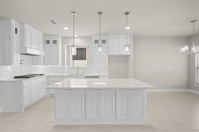 kitchen with white cabinetry, a chandelier, and a center island