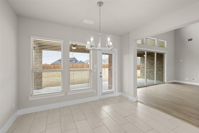 doorway featuring light tile flooring and a notable chandelier