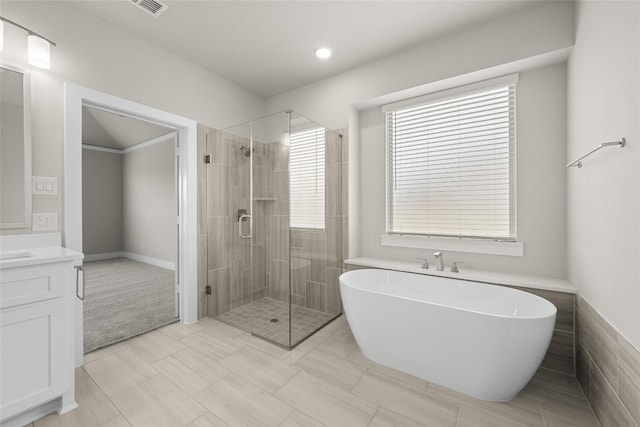 bathroom featuring tile flooring, separate shower and tub, and vanity