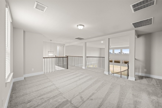 basement with an inviting chandelier and light colored carpet