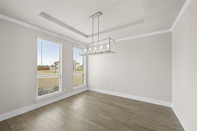 unfurnished dining area featuring a raised ceiling, ornamental molding, dark hardwood / wood-style floors, and an inviting chandelier