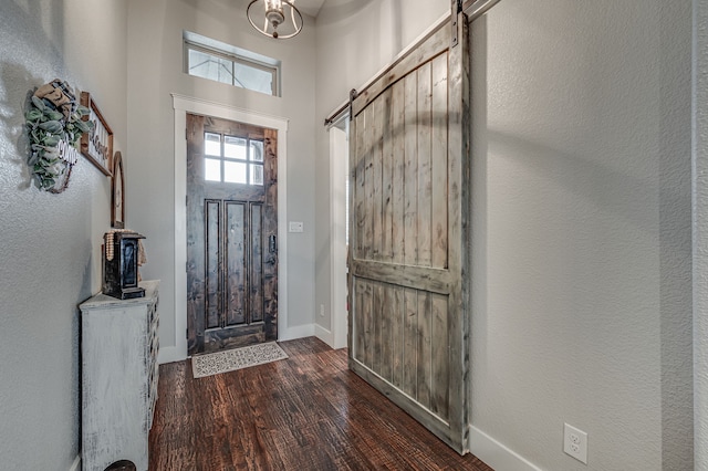 foyer featuring a barn door and dark hardwood / wood-style floors