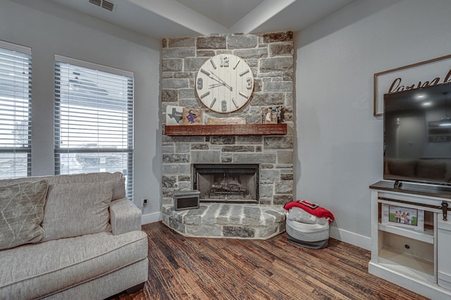 living room featuring dark hardwood / wood-style flooring, a fireplace, and a healthy amount of sunlight