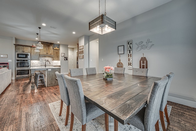 dining space with dark hardwood / wood-style flooring and sink