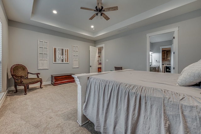 bedroom with a tray ceiling, ceiling fan, and carpet flooring