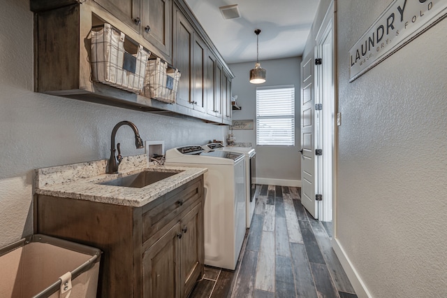 laundry area with sink, dark hardwood / wood-style floors, cabinets, and independent washer and dryer