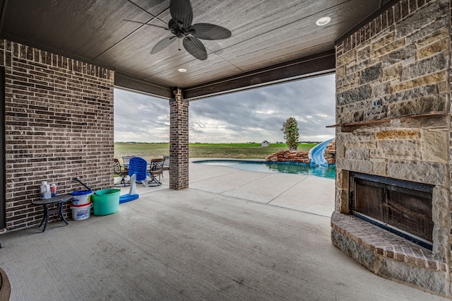 view of patio / terrace with ceiling fan and an outdoor stone fireplace