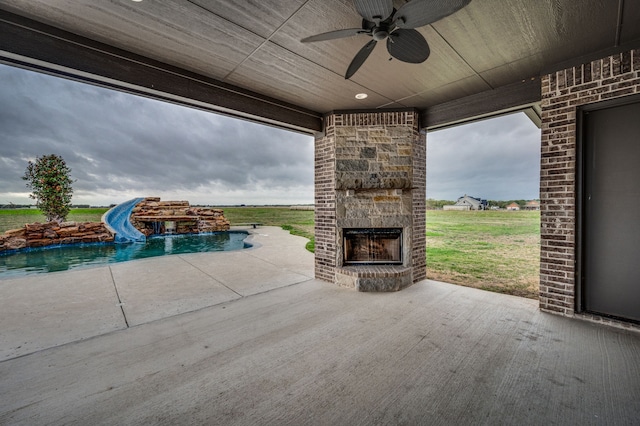 view of patio with ceiling fan and an outdoor stone fireplace