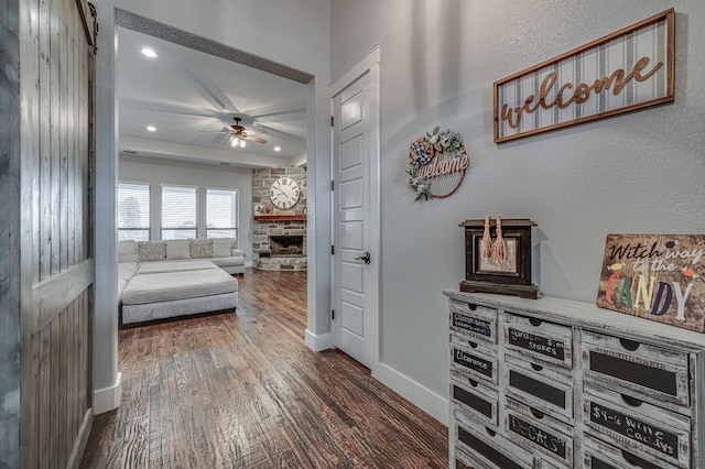 bedroom with dark wood-type flooring and a stone fireplace