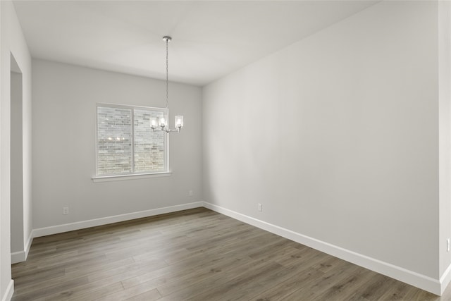 unfurnished dining area with a chandelier and hardwood / wood-style floors