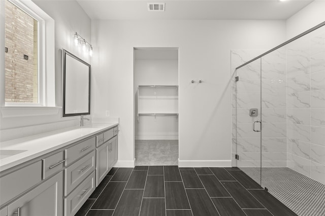 bathroom featuring vanity and a shower with door