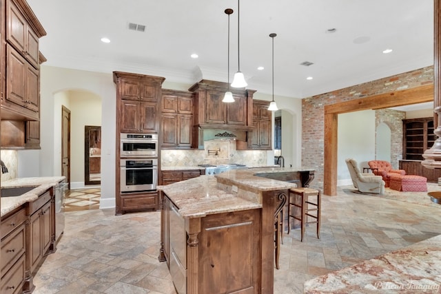 kitchen with a kitchen bar, backsplash, light tile flooring, and an island with sink