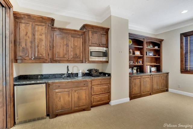 kitchen with stainless steel microwave, sink, refrigerator, crown molding, and light colored carpet