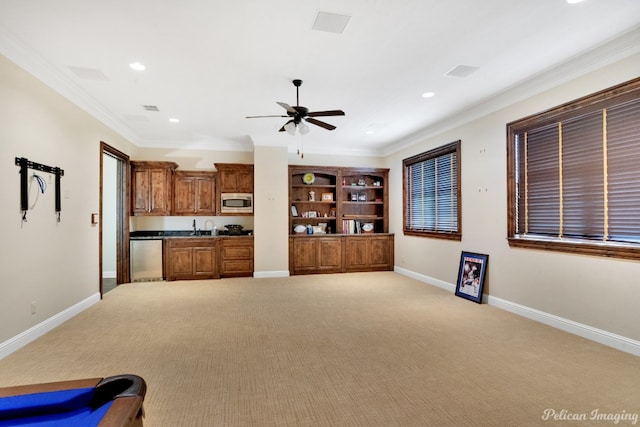 unfurnished living room featuring ceiling fan, crown molding, sink, and light colored carpet