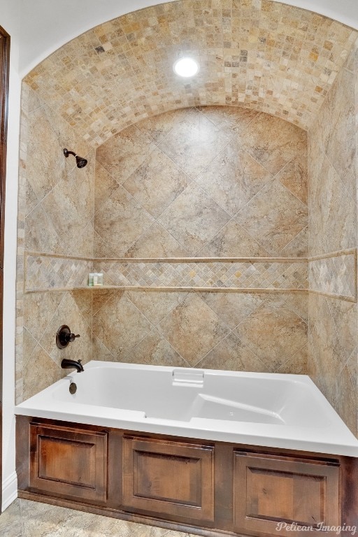 bathroom featuring tiled shower / bath and tile floors