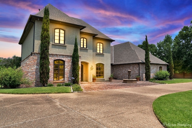 french country home featuring a lawn