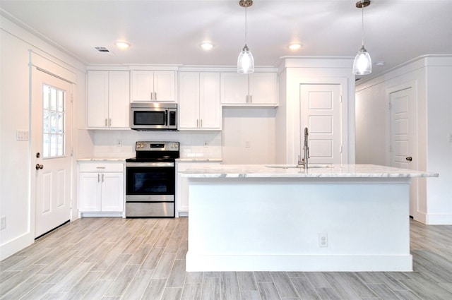 kitchen with appliances with stainless steel finishes, sink, white cabinetry, and pendant lighting