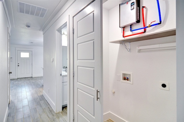 laundry area featuring light hardwood / wood-style floors, hookup for an electric dryer, ornamental molding, and hookup for a washing machine