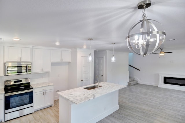 kitchen featuring sink, light hardwood / wood-style floors, stainless steel appliances, decorative light fixtures, and white cabinetry