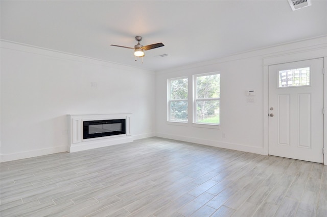 unfurnished living room featuring ceiling fan, crown molding, and light hardwood / wood-style floors