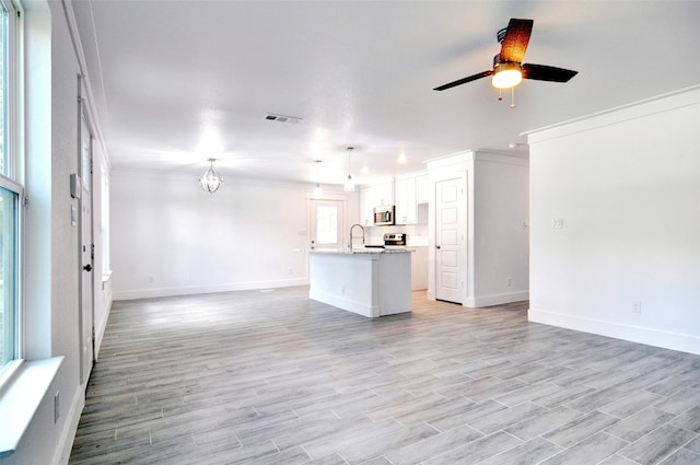 kitchen featuring pendant lighting, ceiling fan, light hardwood / wood-style flooring, white cabinetry, and a kitchen island with sink