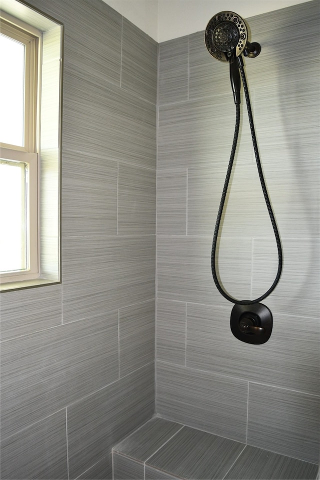 bathroom featuring a healthy amount of sunlight and tiled shower