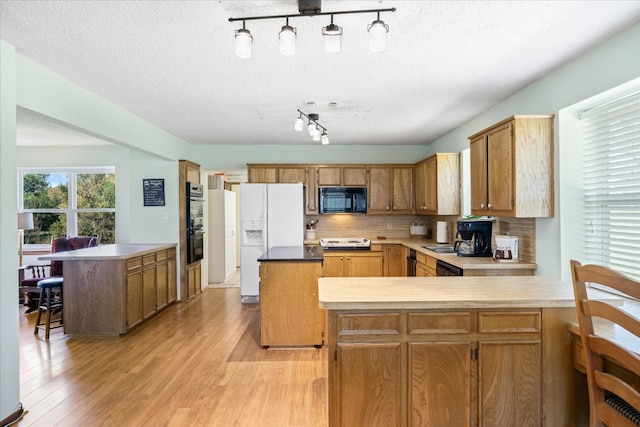 kitchen with rail lighting, backsplash, a textured ceiling, and black appliances