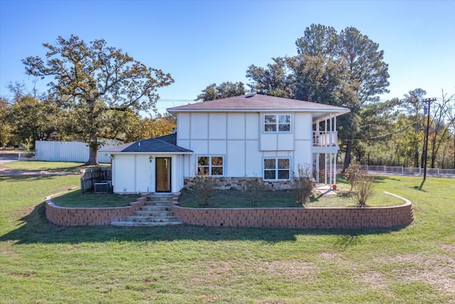 view of front of home with central AC and a front yard