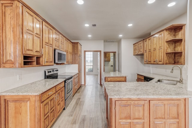 kitchen with tasteful backsplash, light wood-type flooring, kitchen peninsula, appliances with stainless steel finishes, and sink