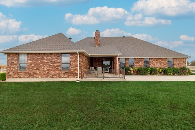 back of property featuring a patio area and a yard