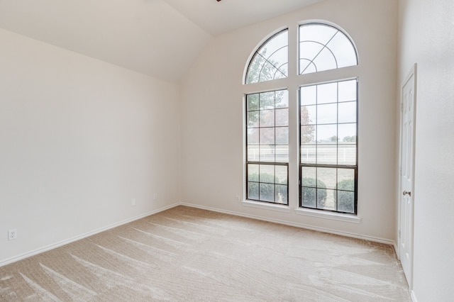 unfurnished room with light carpet, lofted ceiling, and a healthy amount of sunlight