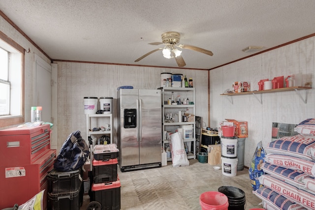 interior space with stainless steel fridge, a textured ceiling, ceiling fan, and crown molding