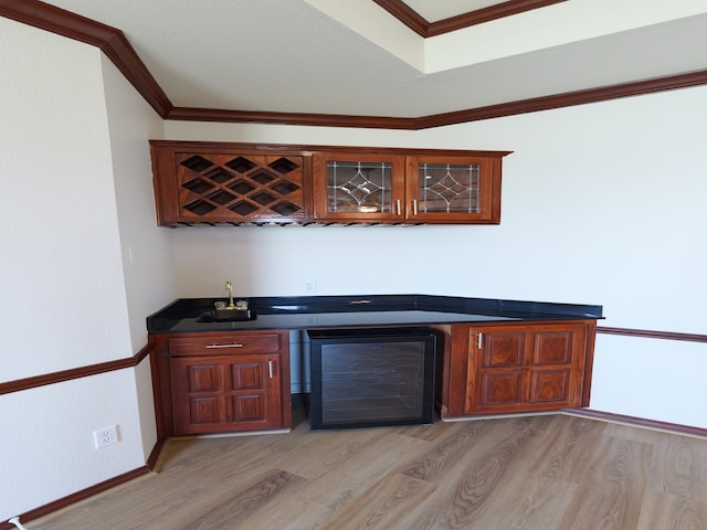 bar with ornamental molding, light wood-type flooring, and beverage cooler